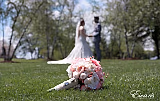 The bride and groom hold hands looking into one another's eyes.