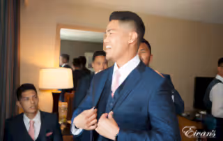 The groom beams with love and happiness as he prepares to his amazing bride.