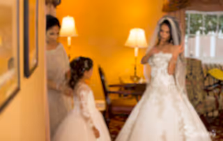 The bride fixes gown while also the bridesmaids and flower girl all prepare for such a tremendous affair.