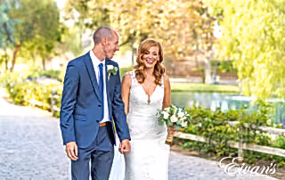 bride and groom walking beside each other in a park