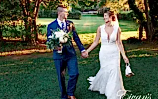 man in black suit and woman in white wedding dress holding bouquet of flowers